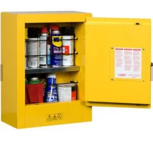Yellow flammable storage cabinet open, containing various aerosol cans and containers, with safety labels and grounding wire visible. Yellow flammable storage cabinet open, containing various aerosol cans and containers, with safety labels and grounding wire visible.